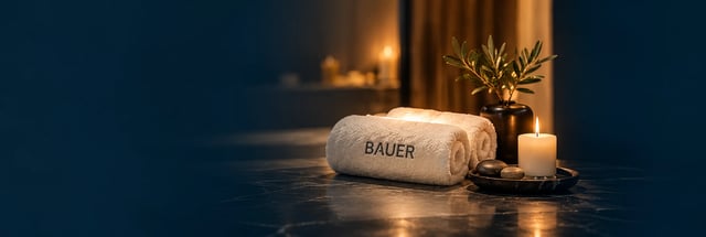 مناشف ⁦BAUER⁩ وشمعة في أجواء دافئة للاسترخاء